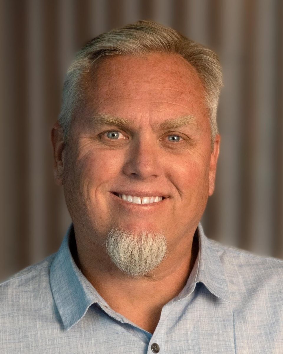 Portrait of Dr. Rob Gent, smiling, in a light blue collared shirt